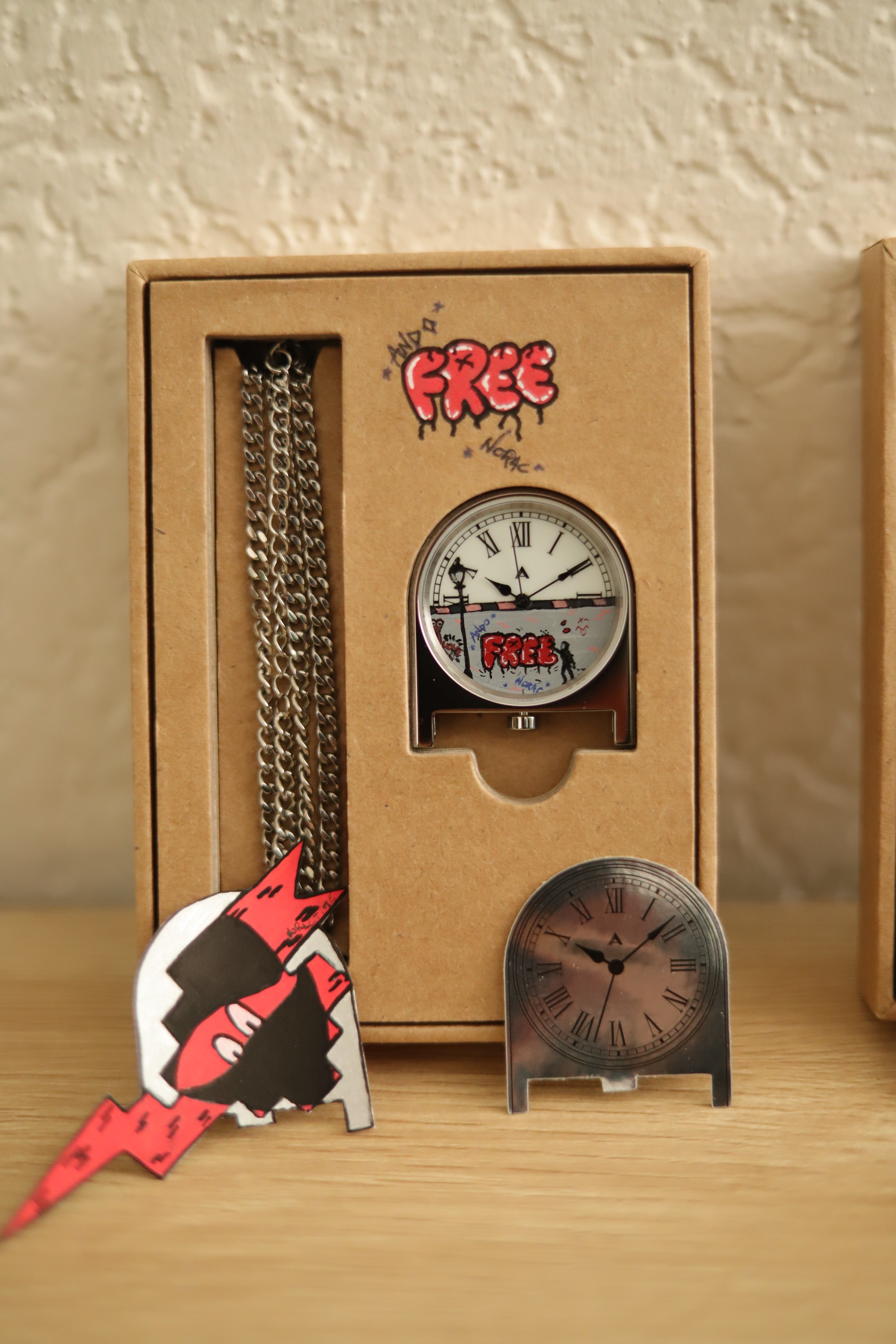 Customized version of the AndoAndoAndo pendant clock, hand painted by NoracTime